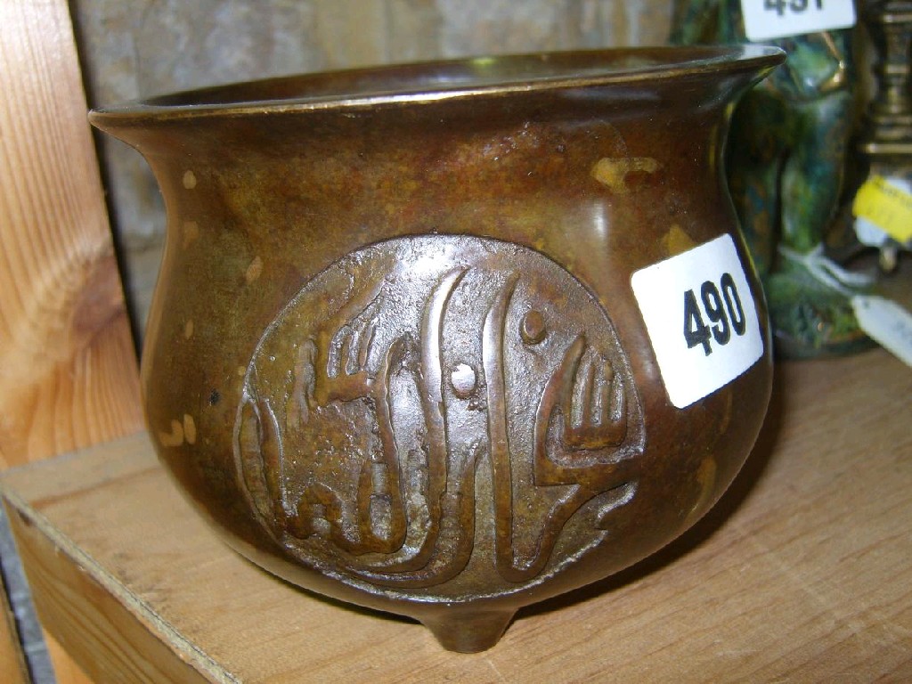 Appraisal: An oriental bronzed vessel with relief character decoration