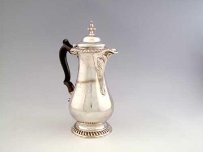 Appraisal: A George III baluster hot water jug on a gadrooned