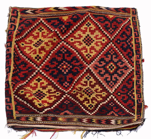 Appraisal: A PERSIAN BRICK GROUND BAG with hooked geometric decoration and