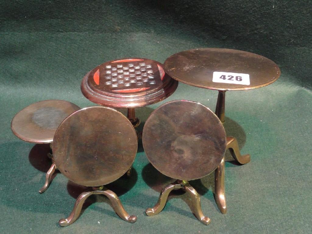 Appraisal: A collection of four miniature brass tilt topped tripod tables