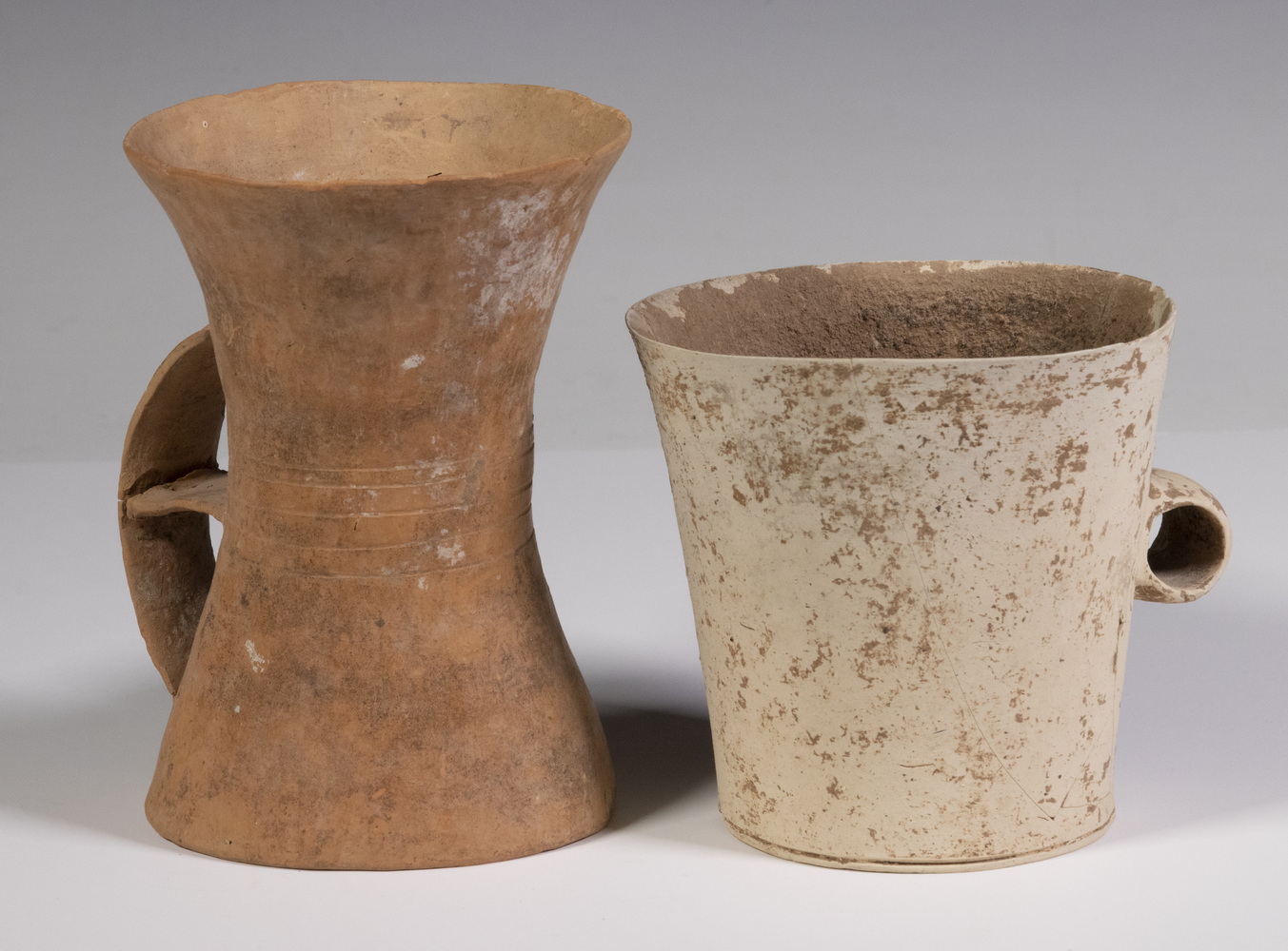 Appraisal: CHINESE HAN DYNASTY POTTERY HANDLED CUPS Both thin walled unglazed