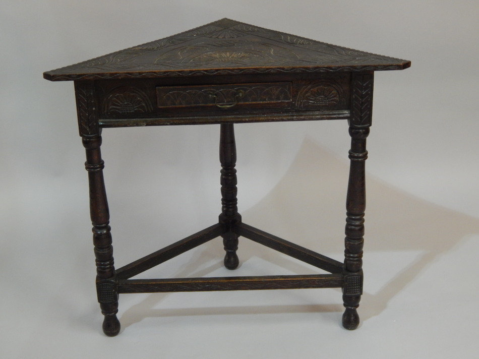 Appraisal: A late Victorian ebonised and carved oak corner table with