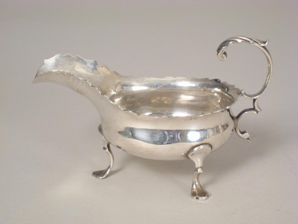 Appraisal: A George III Sauce Boat with shaped rim leafage scroll