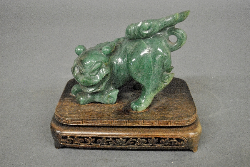 Appraisal: - Chinese carved jade Foo dog on a carved wood