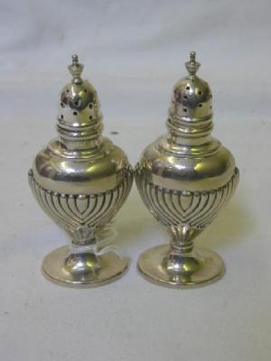 Appraisal: A PAIR OF SILVER PEPPERS of oval urn form with