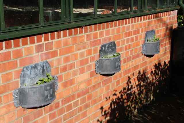 Appraisal: A SET OF EIGHT WALL MOUNTED 'D' SHAPED LEAD PLANTERS