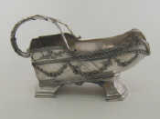 Appraisal: A French silver plated wine cradle with garlands leafage and