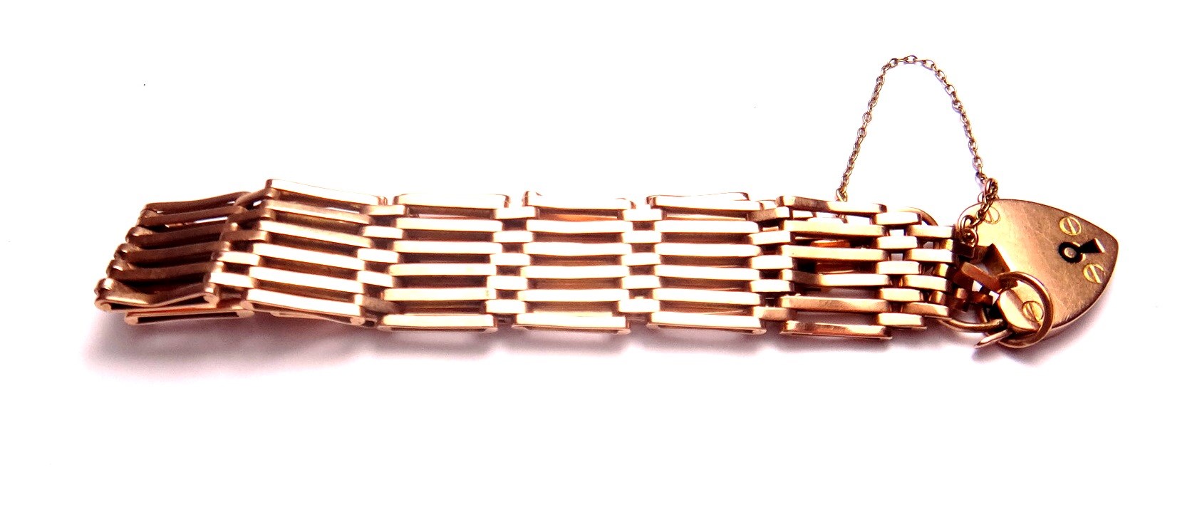 Appraisal: A gold bar and oval link gate bracelet with a