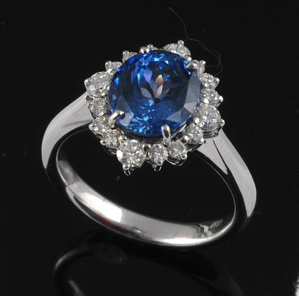 Appraisal: A SAPPHIRE AND DIAMOND CLUSTER RING The oval cut blue