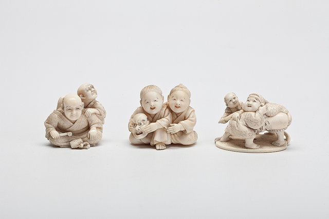 Appraisal: THREE JAPANESE IVORY NETSUKE two boys seated playing with a