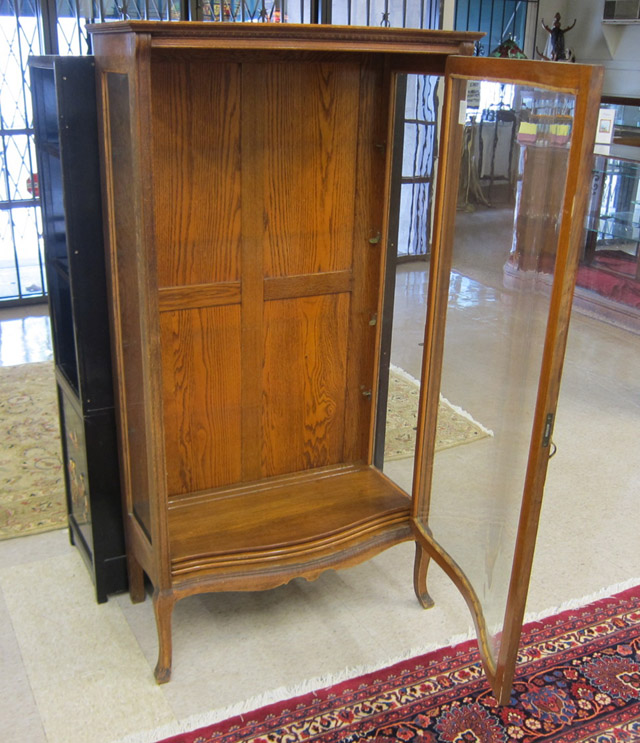 Appraisal: AN OAK AND CURVED GLASS CHINA CABINET American c having