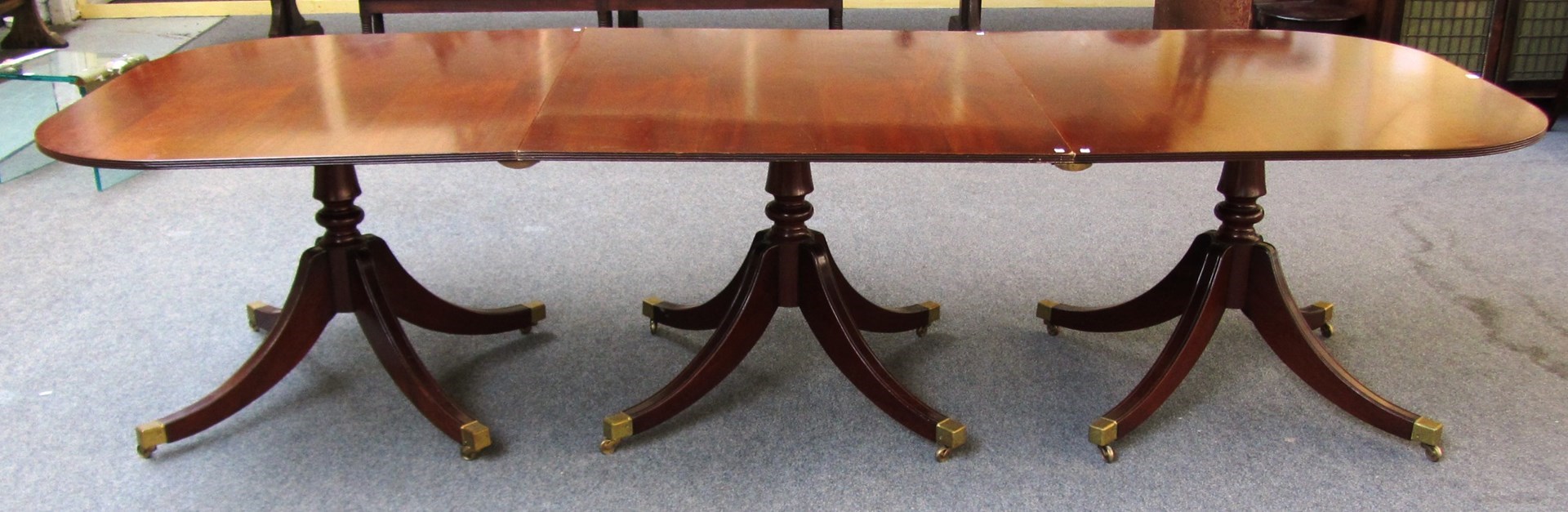 Appraisal: A Regency style mahogany triple pillar dining table on twelve