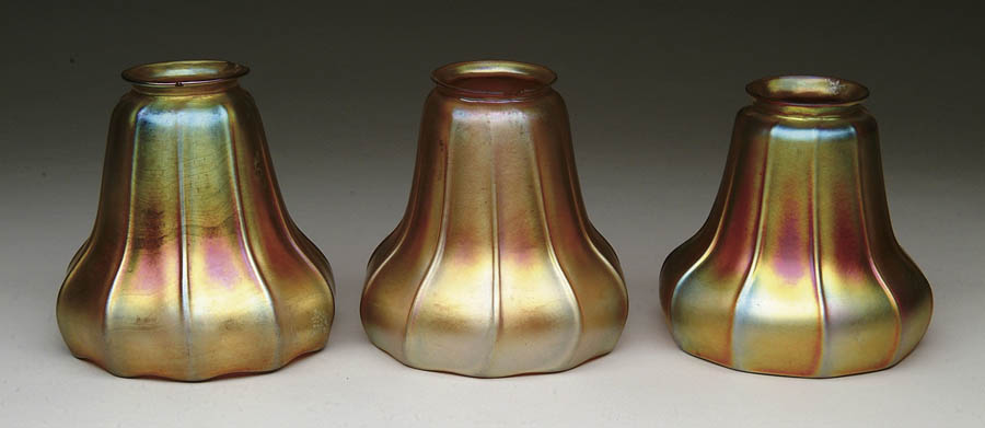 Appraisal: THREE AMERICAN ART GLASS SHADES Three gold bell-shaped shades are