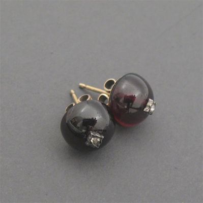 Appraisal: A pair of diamond set cabochon garnet mounted gold ear