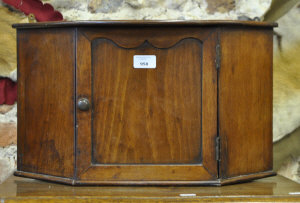 Appraisal: A small Victorian walnut hanging corner cupboard with panelled door