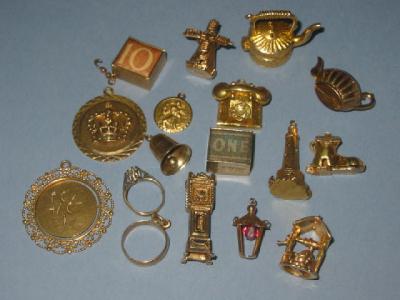 Appraisal: SIXTEEN CT GOLD CHARMS including a lighthouse windmill and a