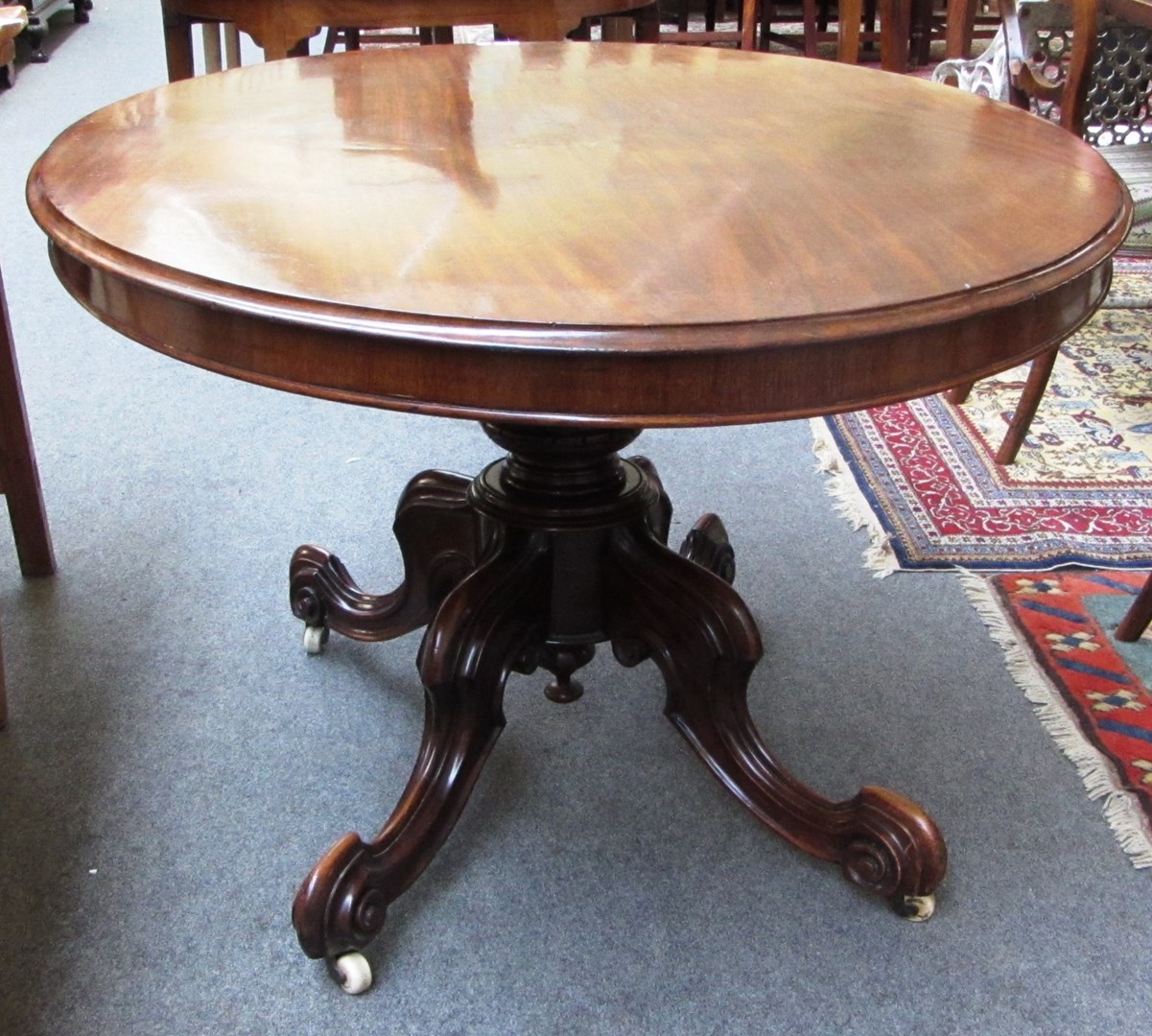 Appraisal: A Victorian mahogany loo table the oval snap-top on turned