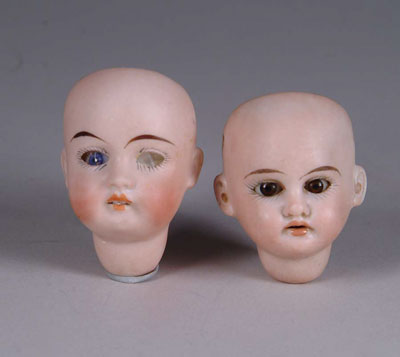 Appraisal: TWO SMALL BISQUE DOLL HEADS One missing eyes both missing