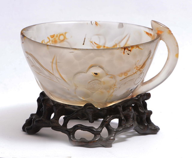 Appraisal: A CHINESE CARVED AGATE CUP incorporating a prunus blossom as