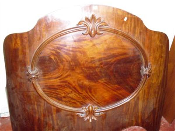 Appraisal: A continental figured mahogany bed end with applied carved decoration