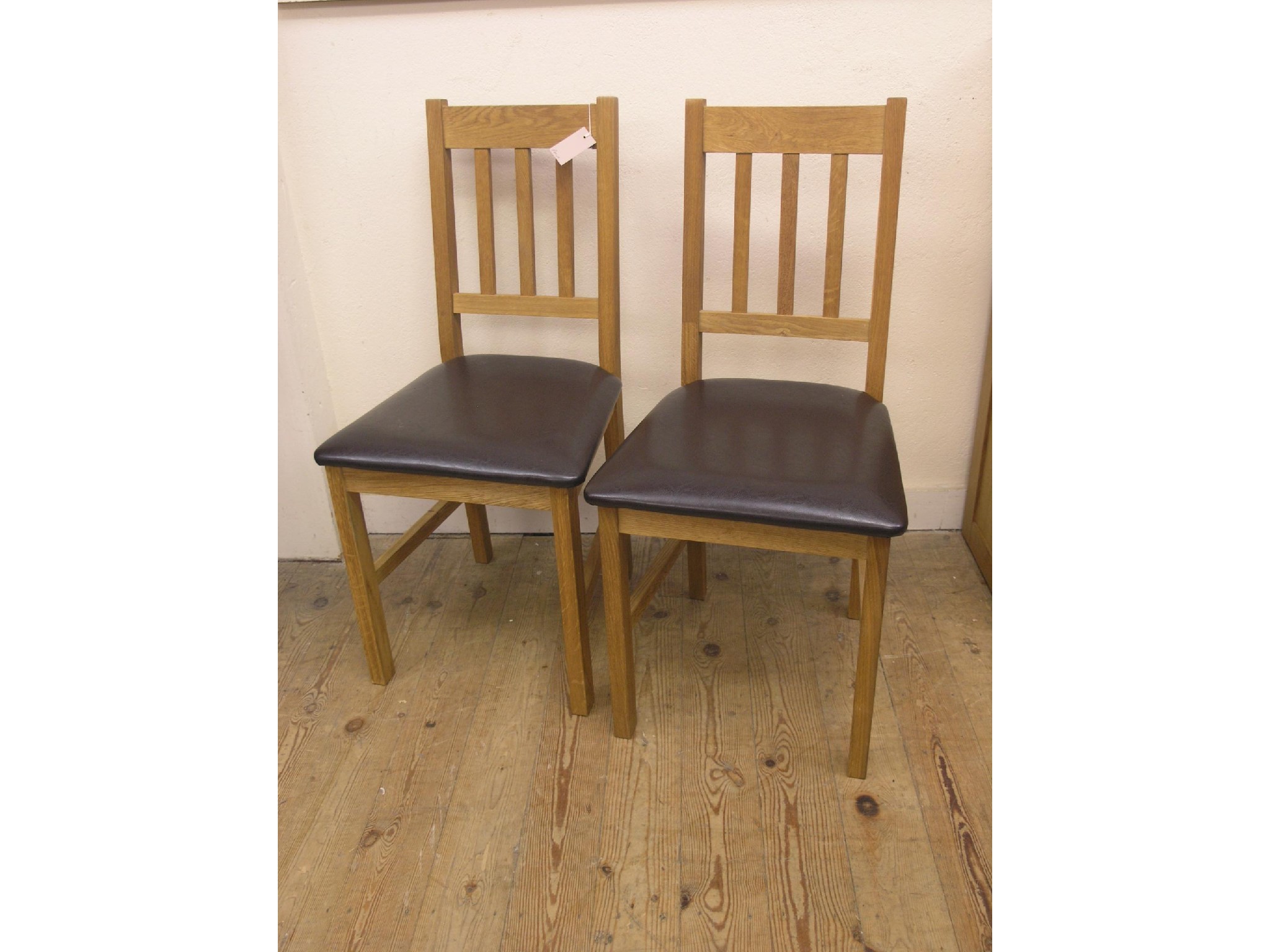 Appraisal: A pair of Julian Bowen solid light oak dining chairs