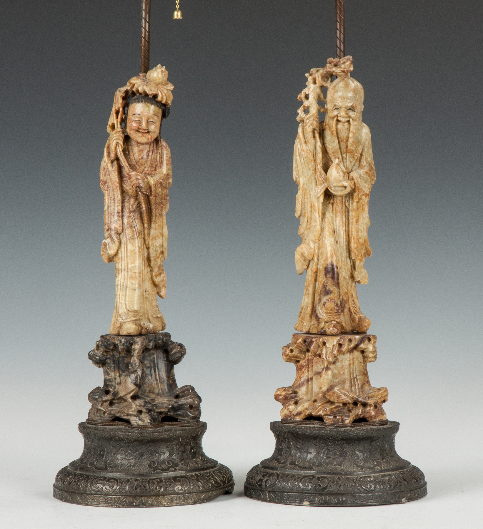 Appraisal: Two Chinese Carved Soapstone Figures th cent Metal bases