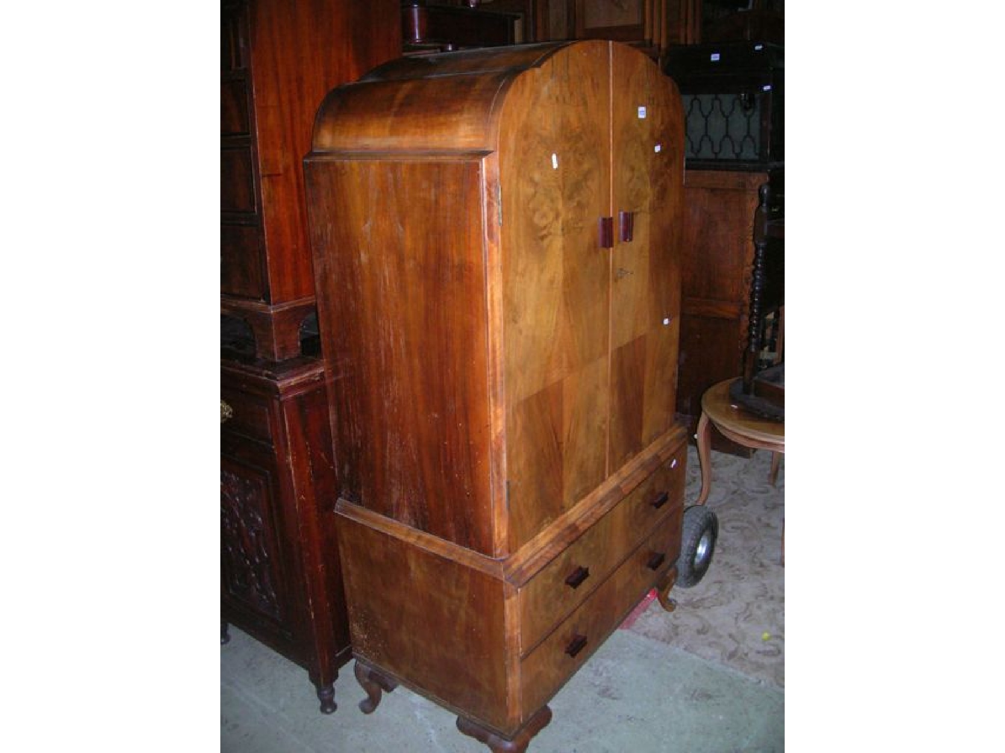 Appraisal: An Art Deco style walnut veneered domed top linen cupboard