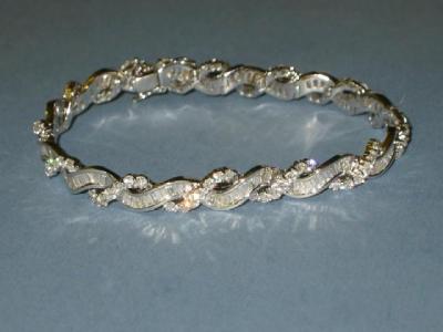 Appraisal: A DIAMOND BRACELET comprising a waved band of channel set