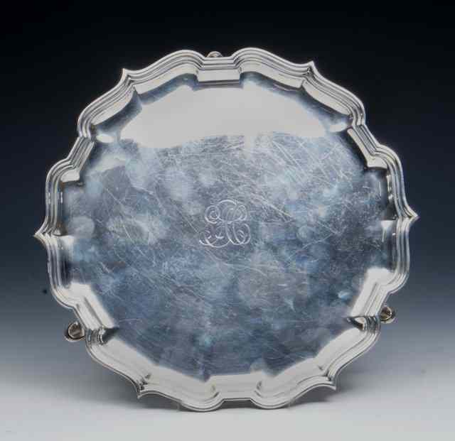 Appraisal: A SILVER SALVER with a Chippendale border and standing on