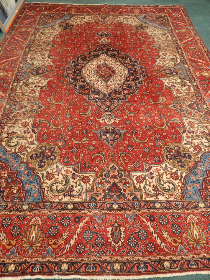 Appraisal: A Persian type carpet with a design of flowers scrolls