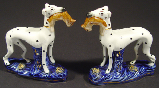 Appraisal: Pair of Staffordshire china whippets clutching rabbits in their mouths