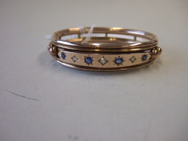 Appraisal: A sapphire and diamond set oval hinged bangle the front