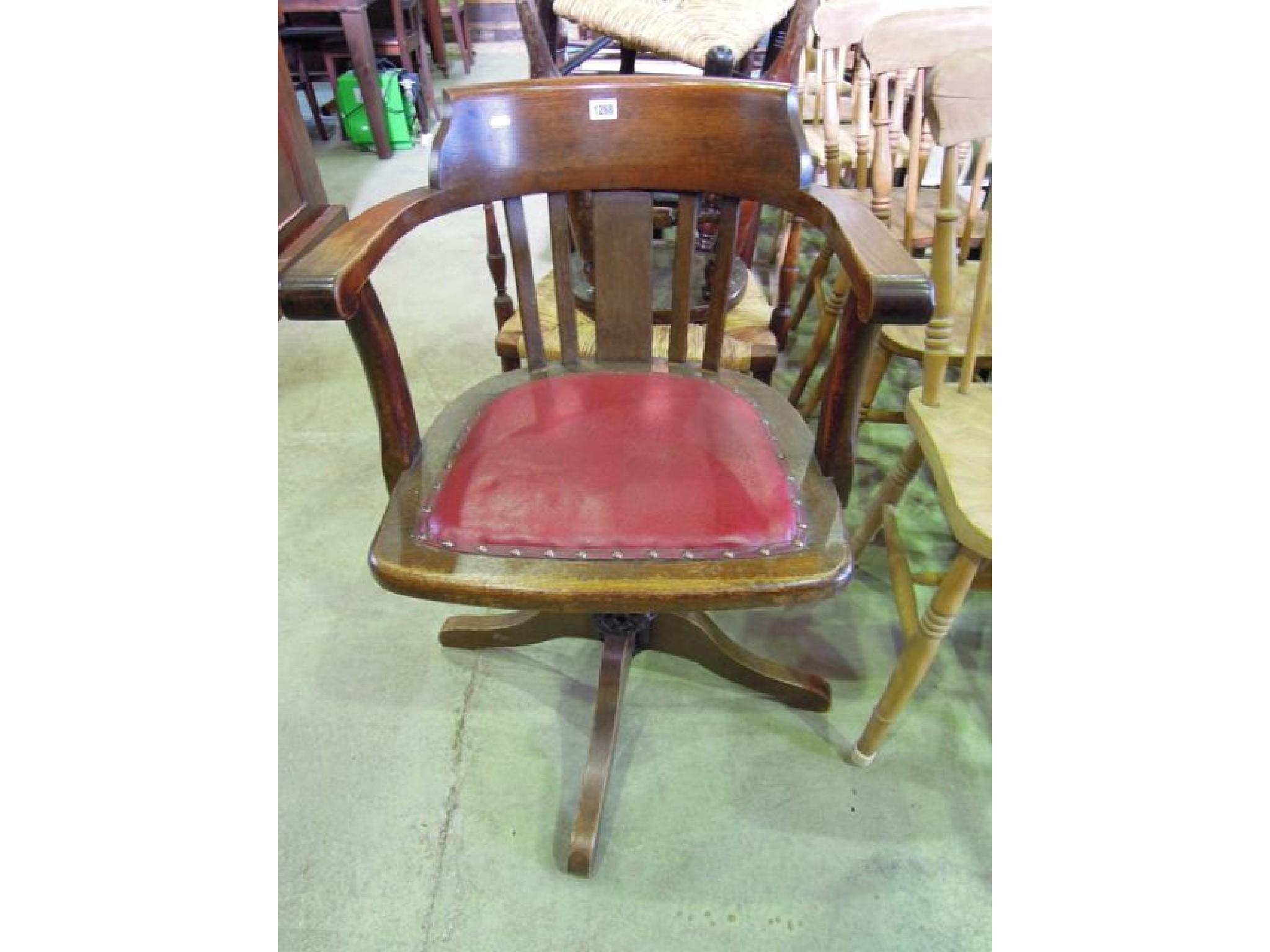 Appraisal: An Edwardian oak swivel office chair with slatted back over