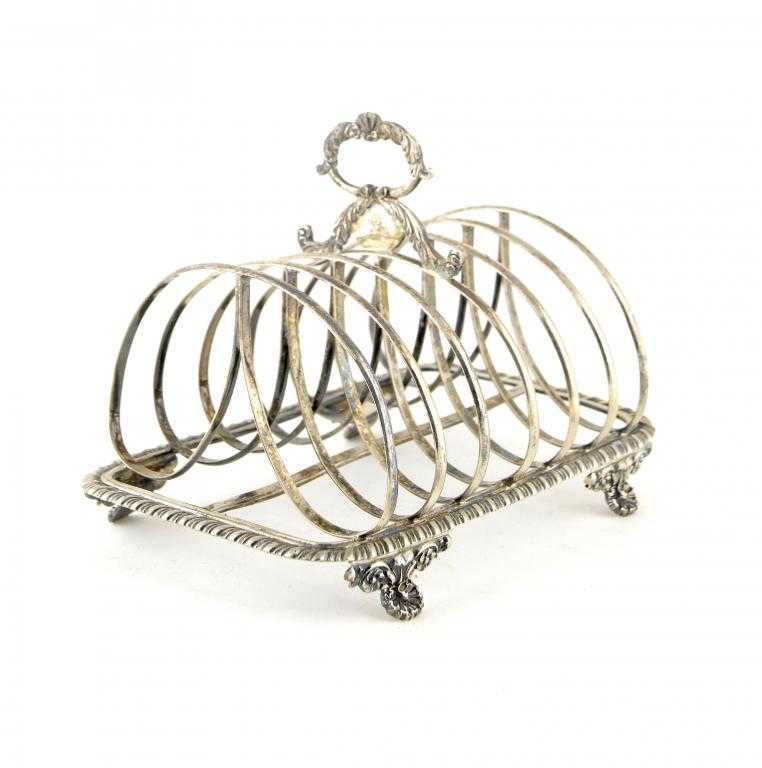 Appraisal: A GEORGE IV TOAST RACK with leafy scrolling loop handle