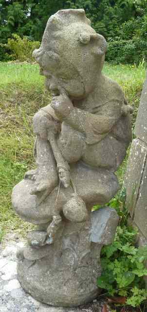 Appraisal: A reconstituted stone figure of an elf sitting on a