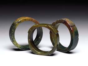 Appraisal: THREE JADE BANGLES Three Chinese carved mottled green and brown