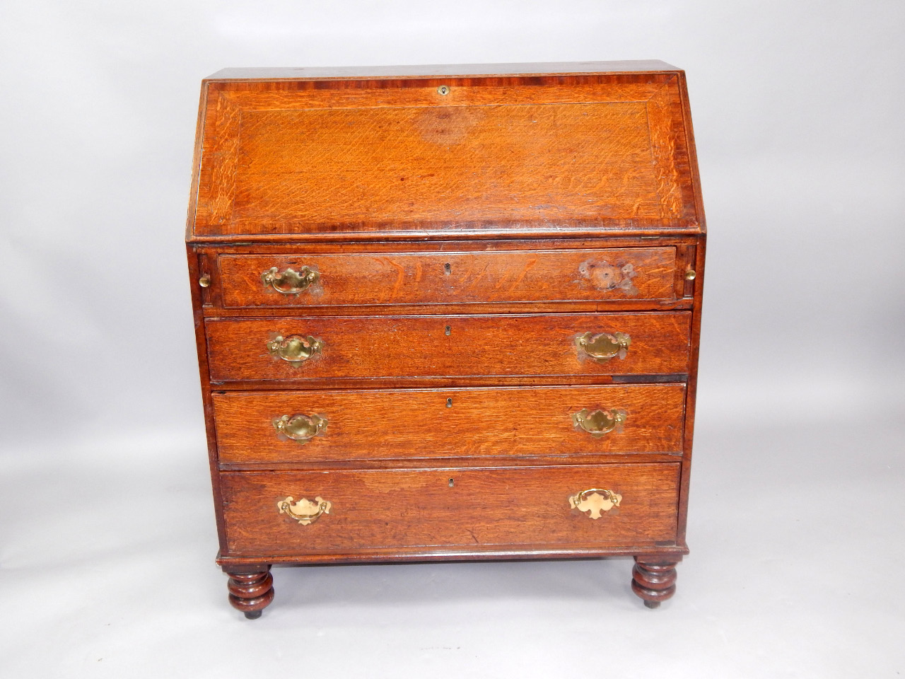 Appraisal: A George III oak and mahogany cross banded bureau fall