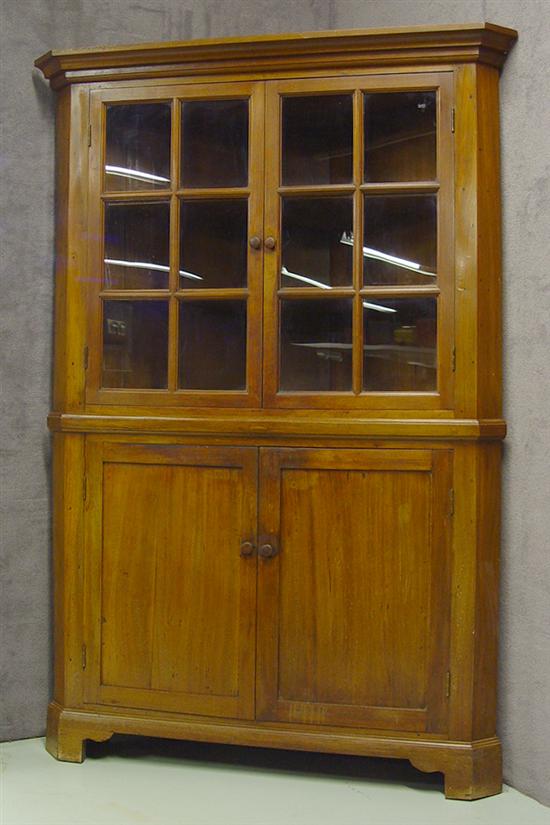 Appraisal: Walnut Corner Cupboard Two six-light glazed doors below ogee cornice