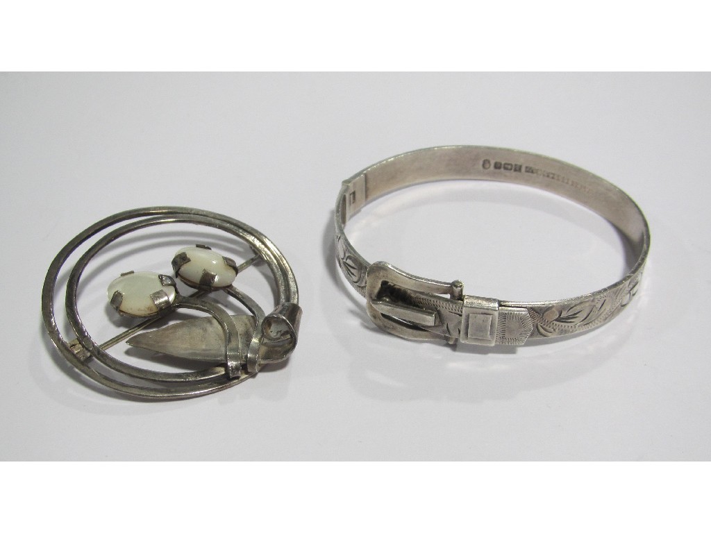 Appraisal: An engraved silver buckle bangle and a silver open circular