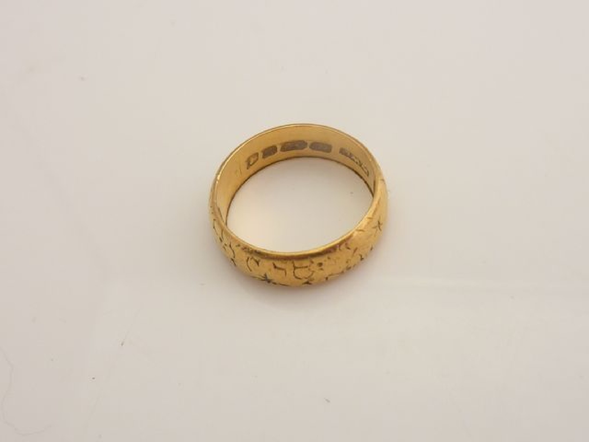 Appraisal: A ct gold wedding band engraved with decorative motifs g