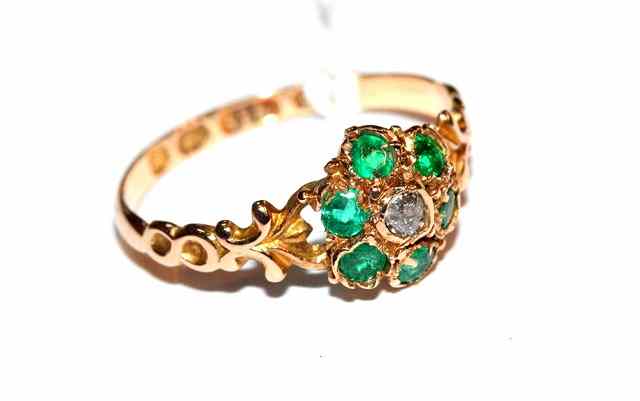 Appraisal: AN EMERALD AND DIAMOND SET DRESS RING in the form