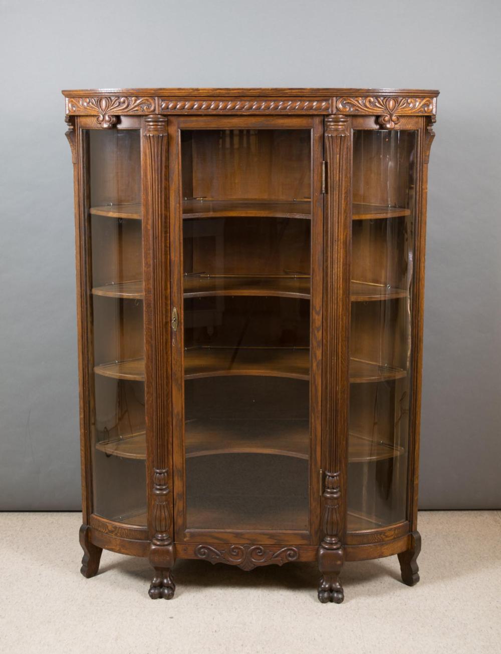 Appraisal: AN OAK AND CURVED GLASS CORNER CHINA CABINET American c