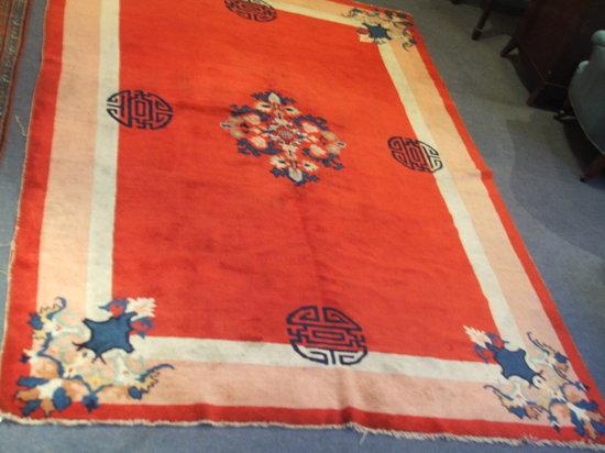 Appraisal: A CHINESE RED GROUND CARPET with a simple foliate medallion