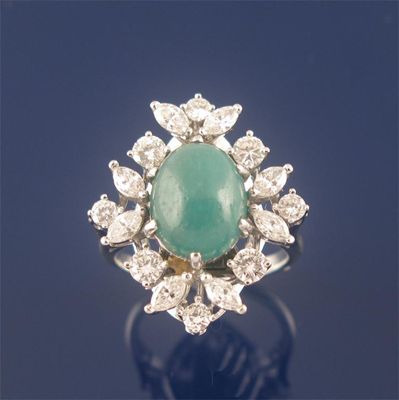 Appraisal: An oval cabochon emerald and diamond cluster ring set within