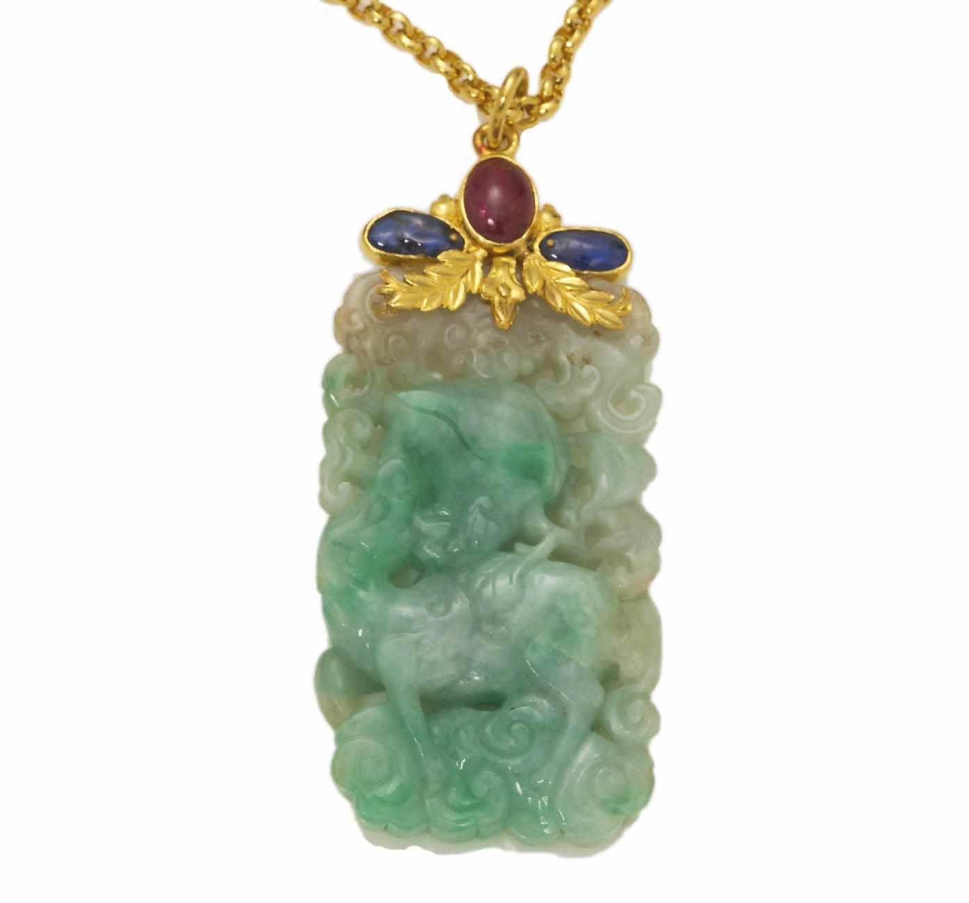 Appraisal: A carved jade sapphire spinel and twenty-four karat gold pendant