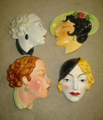 Appraisal: FOUR ART DECO POTTERY WALL MASKS modelled as ladies faces