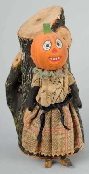 Appraisal: Pumpkin Head Woman by Tree Stump Candy Container Description A