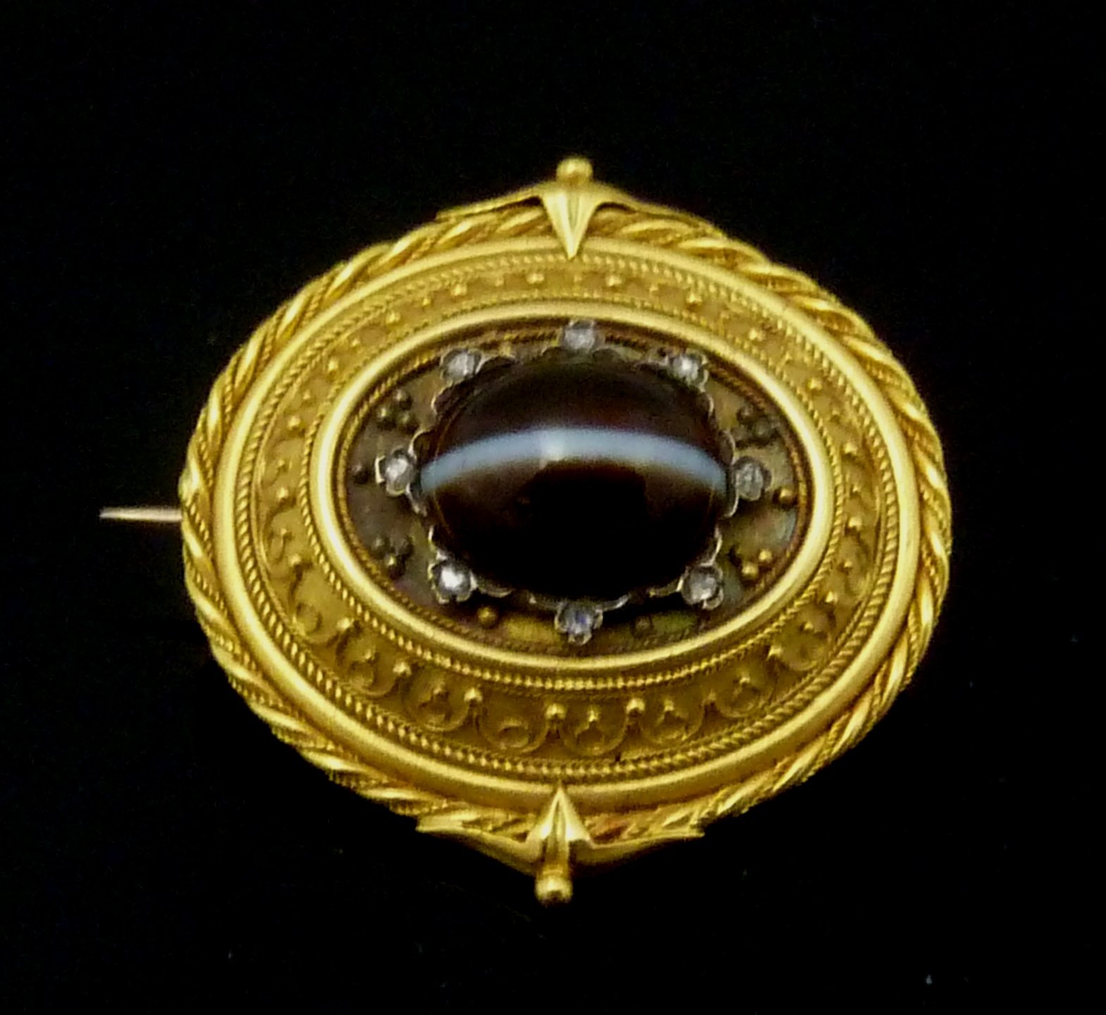 Appraisal: A Victorian oval brooch centred by a banded agate cabochon