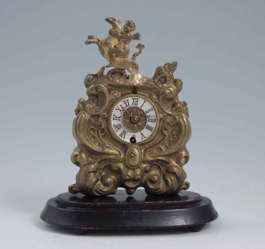 Appraisal: MINIATURE FIGURAL BRASS L'EPINE CLOCK UNDER DOME Embossed brass case