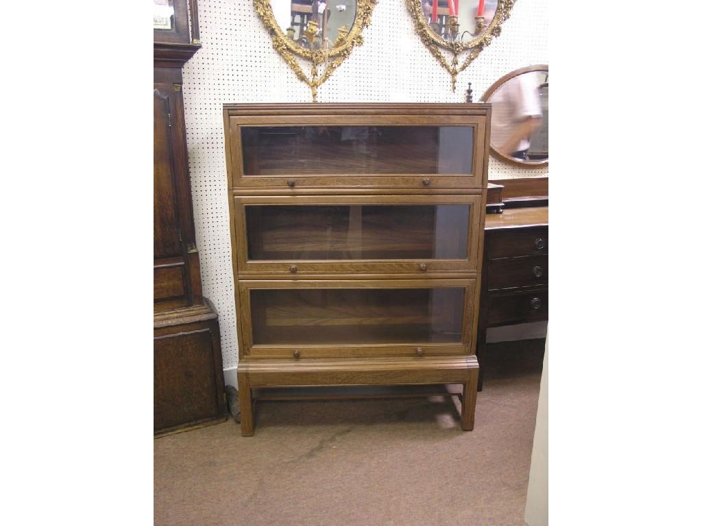 Appraisal: A solid teak sectional bookcase three glazed sections on stand